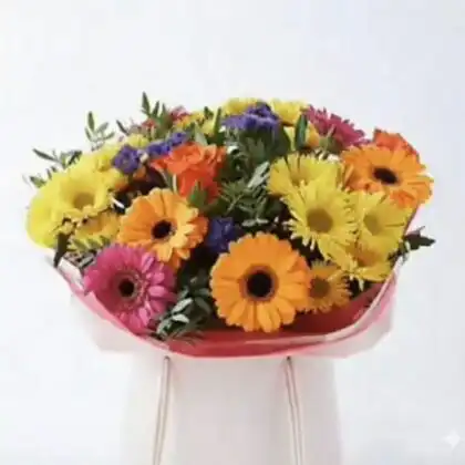 Wishlist 13 A hand-tied orange and yellow gerbera bouquet accented with roses and lush greenery in a bright setting.