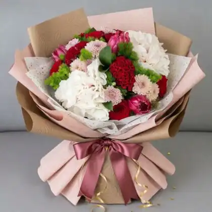 A stunning white rose and hydrangea bouquet arranged with lush greenery in a premium presentation.