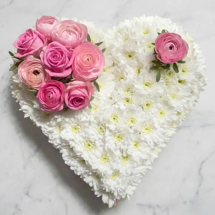 Pink & White Eternal Heart Funeral Tribute 1 A funeral flower heart arrangement featuring delicate pink roses and white lilies as a peaceful memorial tribute.