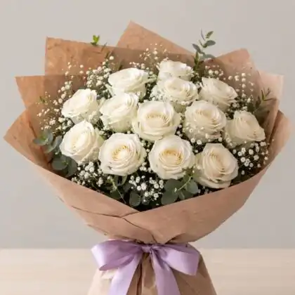 A hand-tied 12 white roses bouquet wrapped in premium paper for a clean and minimalist look.