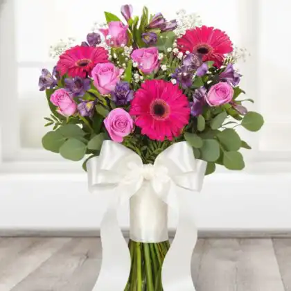 Vibrant Pink Lady bouquet featuring pink gerbera daisies, roses, and purple alstroemeria wrapped in soft pink paper.