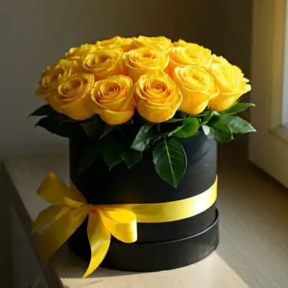 A luxury yellow rose box featuring fresh blooms arranged in a matte black hatbox with a silk ribbon.