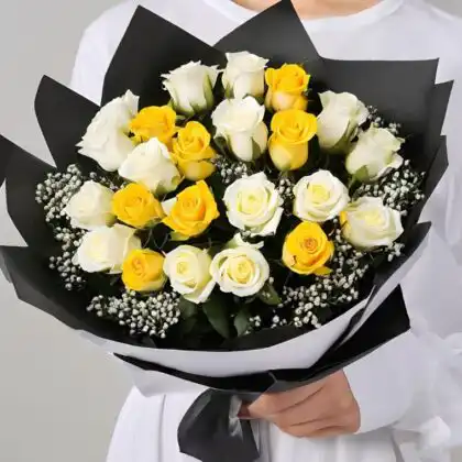 A beautiful yellow and white rose bouquet arranged with fresh green leaves in a stylish wrap.