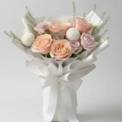 A fresh peach and pink roses bouquet arranged with white chrysanthemums and greenery in premium white paper wrapping.