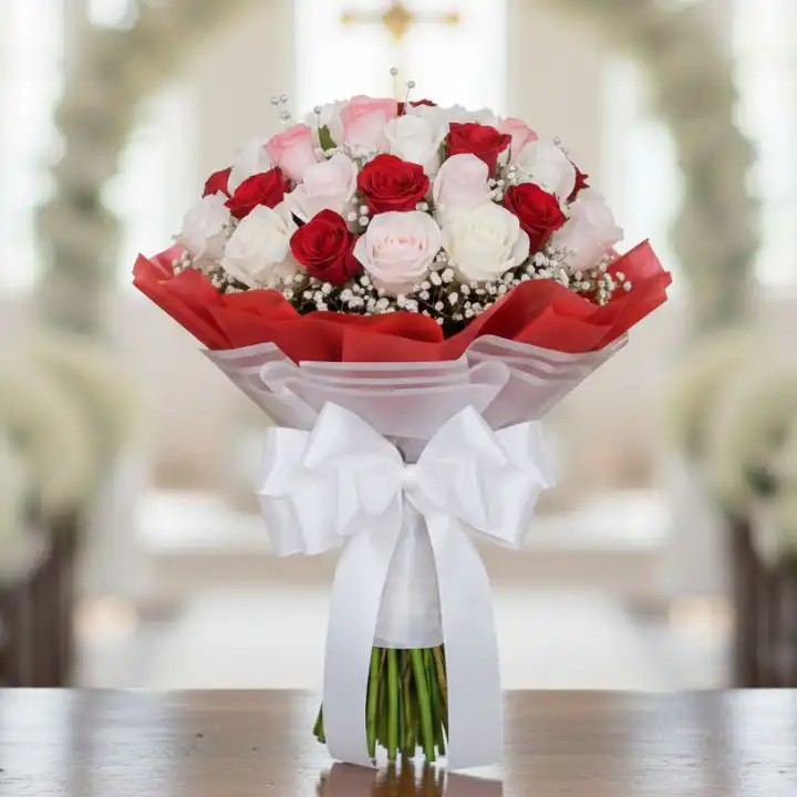 The Eternal Romance Bouquet 1 A fresh red white pink rose bouquet wrapped in premium paper with a decorative ribbon on a wooden table.
